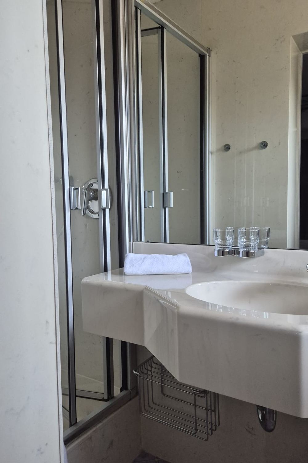 Waschbecken mit Spiegelschrank, Handtuch und Gläsern