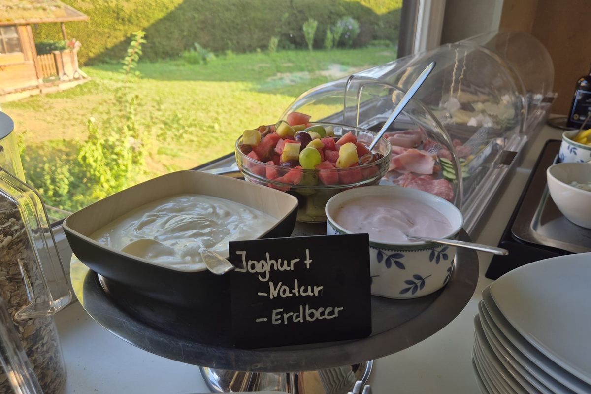 Joghurt natur und mit Erdbeere, dazu frisch geschnittenes Obst und Müsli
