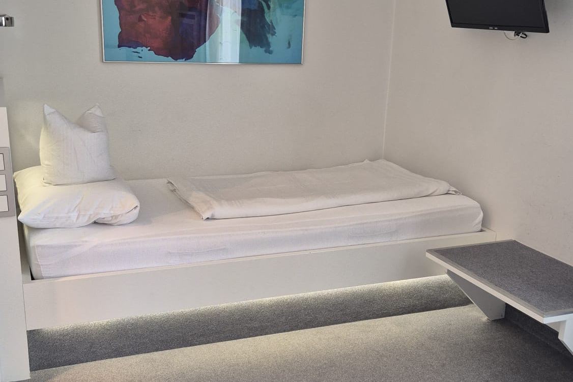 Einzelzimmer mit Bett, Wandbild und Fernseher